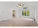 Spacious main bedroom with vaulted ceiling, ceiling fan, and large windows with a backyard view at 1021 Reaves Dr Dr, Chapel Hill, NC 27516
