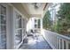 Relaxing balcony with seating, ceiling fan, and views of the surrounding trees at 1023 Kelton Cottage Way, Morrisville, NC 27560