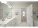 Bright bathroom with dual sinks and a door opening to a bedroom at 1023 Kelton Cottage Way, Morrisville, NC 27560