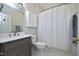 Bathroom with white tile floor, gray vanity, and shower with white shower curtain at 1023 Kelton Cottage Way, Morrisville, NC 27560