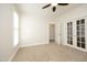 Bright room featuring neutral carpet, a ceiling fan, and white French doors at 1023 Kelton Cottage Way, Morrisville, NC 27560