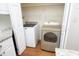 Laundry closet featuring side-by-side washer and dryer with storage shelves at 1023 Kelton Cottage Way, Morrisville, NC 27560