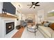 Bright living room featuring a fireplace, ceiling fan, and an open layout with a dining area at 1023 Kelton Cottage Way, Morrisville, NC 27560