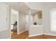 Hallway featuring hardwood floors and neutral paint, leading to multiple rooms at 1081 Wirewood Dr # 302, Raleigh, NC 27605
