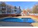 Community swimming pool surrounded by lounge chairs and brick fencing at 1081 Wirewood Dr # 302, Raleigh, NC 27605