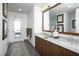 Well-lit bathroom with dual sinks, a marble countertop, modern fixtures, and access to the bedroom at 110 N Corcoran St # 2502, Durham, NC 27701