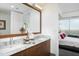 Bright bathroom featuring a dual sink vanity with a marble countertop and views to the bedroom at 110 N Corcoran St # 2502, Durham, NC 27701