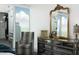 Stylish dressing area with a decorative chair, dresser, and large framed mirror reflecting a cityscape at 110 N Corcoran St # 2502, Durham, NC 27701