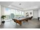 Spacious game room featuring a high-end pool table, hardwood floors, and expansive windows with breathtaking city views at 110 N Corcoran St # 2502, Durham, NC 27701