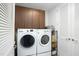 Laundry room with front-load washer and dryer, overhead cabinets, and extra storage space at 110 N Corcoran St # 2502, Durham, NC 27701