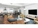 Open floorplan living room with hardwood floors, modern kitchen, comfortable seating, and lots of sunlight at 110 N Corcoran St # 2502, Durham, NC 27701