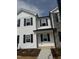 New two-story townhome with white siding, black shutters, and stone accents on the exterior at 1104 Brookrun Dr, Oxford, NC 27565