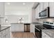 Open kitchen with granite countertops, stainless appliances and white cabinetry overlooking living area at 12 Crow Field St, Roxboro, NC 27574