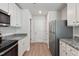 Galley kitchen boasts granite counters, new stainless steel appliances, and ample white cabinetry at 12 Crow Field St, Roxboro, NC 27574