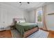 A spacious bedroom with a large window, wooden bed frame, and hardwood floors at 1310 S 8Th St, Lillington, NC 27546
