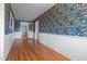 Inviting hallway features unique wallpaper, wainscoting, and gleaming hardwood floors at 1310 S 8Th St, Lillington, NC 27546