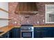 Close up of modern kitchen with custom cabinets, stainless steel range, brick backsplash, and wood countertops at 1310 S 8Th St, Lillington, NC 27546