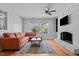 Light-filled living room featuring a fireplace, large window with backyard views, and hardwood floors at 1310 S 8Th St, Lillington, NC 27546