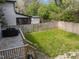 Fenced back yard with small lawn and deck with grill on a sunny day at 1515 E Jones St, Raleigh, NC 27610