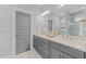 Bathroom featuring double vanity with granite countertops, gray cabinetry, and neutral flooring at 1515 E Jones St, Raleigh, NC 27610