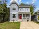 Charming two-story home with a welcoming front porch, red door, and landscaped front yard at 1515 E Jones St, Raleigh, NC 27610