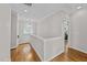 Hallway with hardwood floors, white walls, and natural light from the window at 1515 E Jones St, Raleigh, NC 27610