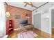 Cozy home office boasts exposed brick accent wall, hardwood floors, and a modern ceiling fan at 1515 E Jones St, Raleigh, NC 27610