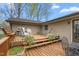 Multi-tiered wooden deck with chairs, a table, and barbecue grill in the backyard at 1525 Rogers Rd, Graham, NC 27253