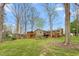 Expansive backyard with mature trees, patio, deck, playhouse, and landscaping at 1525 Rogers Rd, Graham, NC 27253