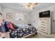 Comfortable bedroom with white walls and a dresser topped with a flat screen television at 1525 Rogers Rd, Graham, NC 27253