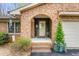 Charming front porch with brick archway, decorated with plants, and seasonal decor at 1525 Rogers Rd, Graham, NC 27253