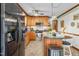 Traditional kitchen with island, seating, and stainless appliances including refrigerator and gas cooktop at 1525 Rogers Rd, Graham, NC 27253