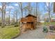 Two-story playhouse nestled in the backyard with a ladder, porch, and gravel area at 1525 Rogers Rd, Graham, NC 27253