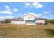 Backyard showcasing a white two-story home with enclosed porch and spacious lawn under a blue sky at 153 Glenn Oak Dr, Sanford, NC 27332