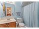 Cozy bathroom featuring a vanity with a single sink, toilet, and blue patterned shower curtain at 153 Glenn Oak Dr, Sanford, NC 27332