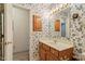 A floral wallpapered bathroom features a single sink vanity with wood cabinets and a large mirror at 153 Glenn Oak Dr, Sanford, NC 27332