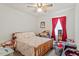 Cozy bedroom with ceiling fan, floral bedding, wood furniture, and bright window with red drapes at 153 Glenn Oak Dr, Sanford, NC 27332