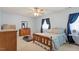 A charming bedroom with a wood bed frame, dresser, and natural light from window with blue curtains at 153 Glenn Oak Dr, Sanford, NC 27332