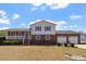 Charming two-story home with a brick facade, a cozy porch, and an attached two-car garage at 153 Glenn Oak Dr, Sanford, NC 27332