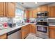 Kitchen featuring stainless steel appliances, oak cabinets, and mosaic tile backsplash at 153 Glenn Oak Dr, Sanford, NC 27332