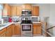 Kitchen area featuring stainless steel appliances, decorative backsplash, and natural wood cabinets at 153 Glenn Oak Dr, Sanford, NC 27332