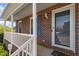 Front porch with brick columns, white railing, and a door with glass panel at 153 Glenn Oak Dr, Sanford, NC 27332