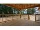 Covered back porch with wood railings and posts that overlooks a wooded back yard at 1565 Pecan Drive # 30, Nashville, NC 27856