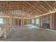 New construction framing reveals a home's open floor plan with exposed ceiling joists and ample natural light at 1565 Pecan Drive # 30, Nashville, NC 27856
