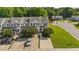 Aerial view showcases townhomes with established lawns, sidewalks, driveways, and mature trees in a well-maintained community at 202 Wimbledon Ct, Clayton, NC 27520
