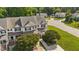 Aerial view of a community of townhomes on a sunny day with green lawns and mature shade trees at 202 Wimbledon Ct, Clayton, NC 27520