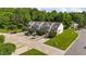 Aerial view features manicured lawns, sidewalks, driveways, and mature trees surrounding these well-maintained townhomes at 202 Wimbledon Ct, Clayton, NC 27520