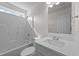 Well-lit bathroom showcasing a shower-tub, white fixtures, and a solid surface vanity at 202 Wimbledon Ct, Clayton, NC 27520