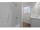 Bathroom with a tub-shower combo and solid surface vanity, complemented by a bright window at 202 Wimbledon Ct, Clayton, NC 27520