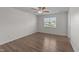 Spacious bedroom with wood-look floors, a ceiling fan, and a large window at 202 Wimbledon Ct, Clayton, NC 27520